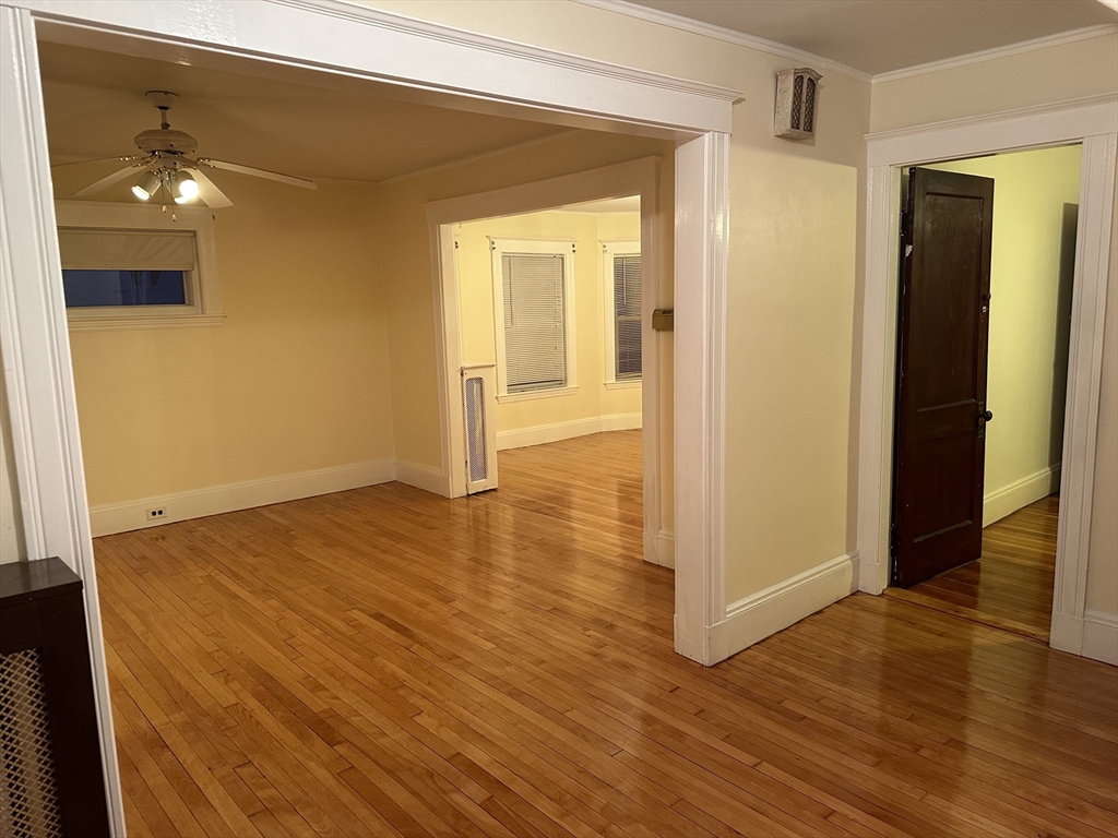 a view of a room with wooden floor and a bathroom