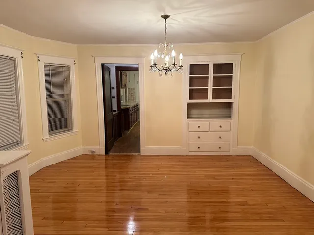 a view of an empty room with cabinet and a window