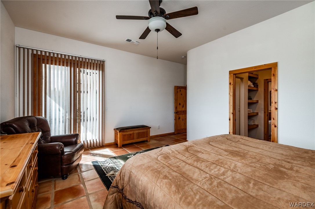 1830 Egar Road Golden Valley, AZ 86413 - Photo 23 of 84 a bedroom with a bed and a chandelier