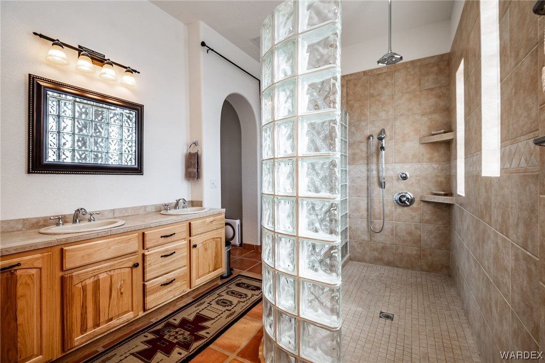 1830 Egar Road Golden Valley, AZ 86413 - Photo 28 of 84 a bathroom with a double vanity sink a mirror and a shower