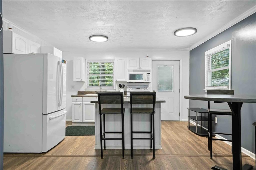 550 Donahoo Road Southeast Silver Creek, GA 30173 - Photo 12 of 29 a kitchen with refrigerator cabinets dining table and chairs