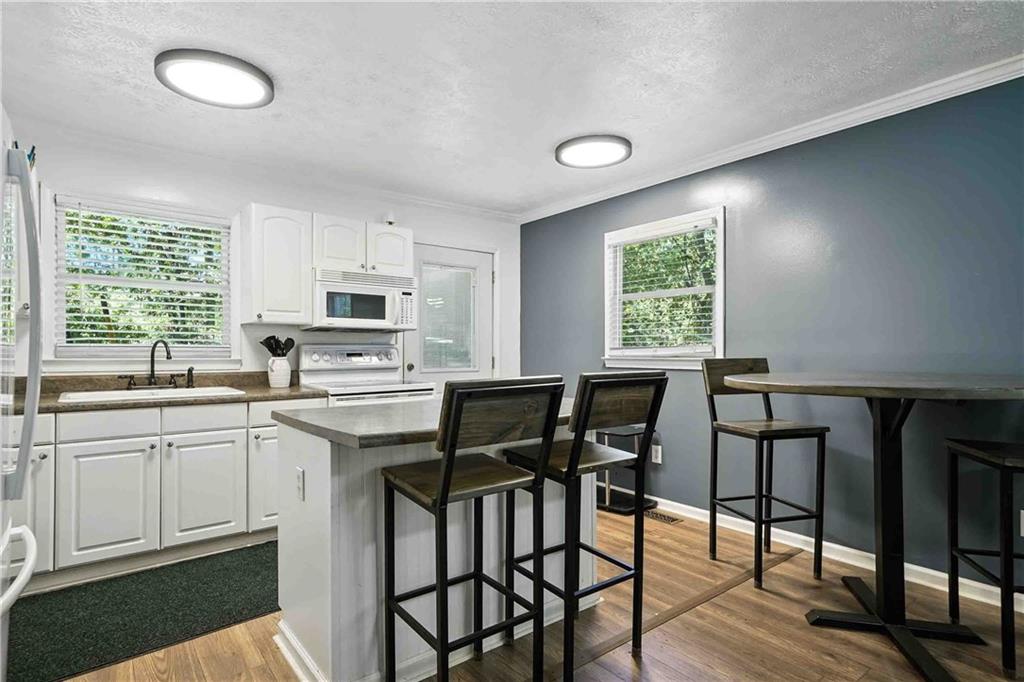 550 Donahoo Road Southeast Silver Creek, GA 30173 - Photo 15 of 29 a kitchen with a table chairs sink and cabinets