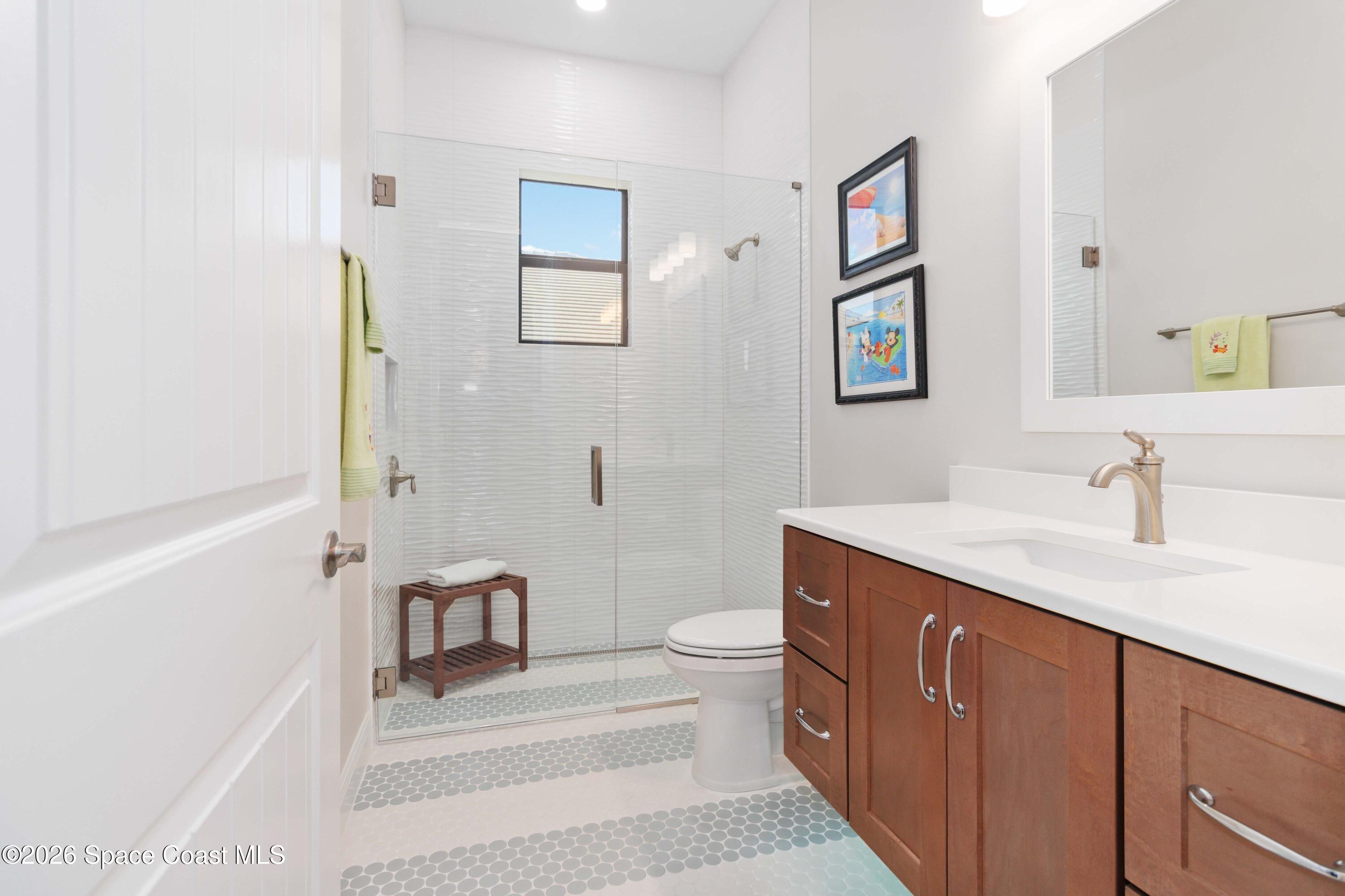 4100 Domain Court Melbourne, FL 32934 - Photo 27 of 52 a spacious bathroom with a granite countertop sink a toilet a shower and a mirror