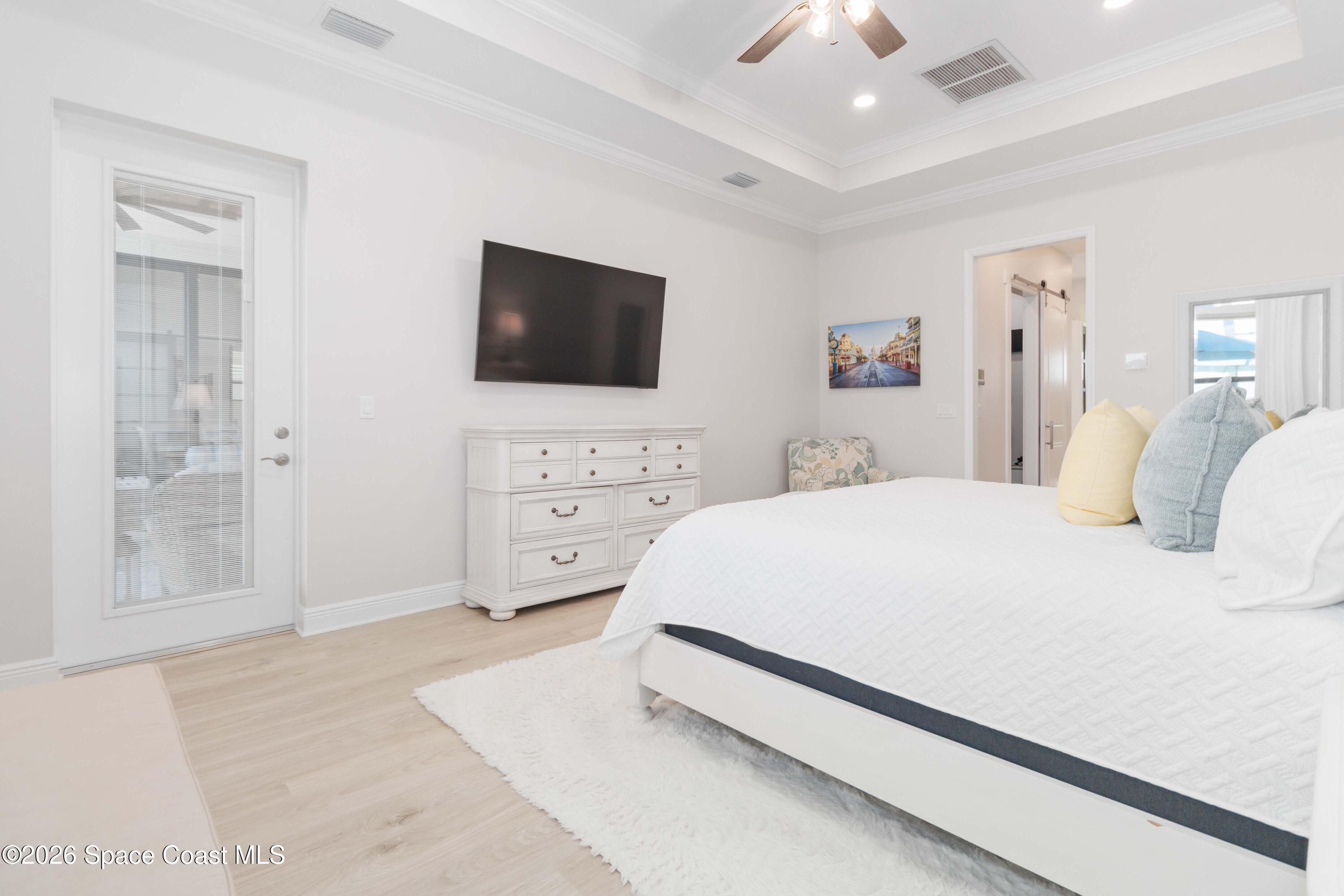 4100 Domain Court Melbourne, FL 32934 - Photo 35 of 52 a bedroom with a bed a mirror on dresser and a flat screen tv