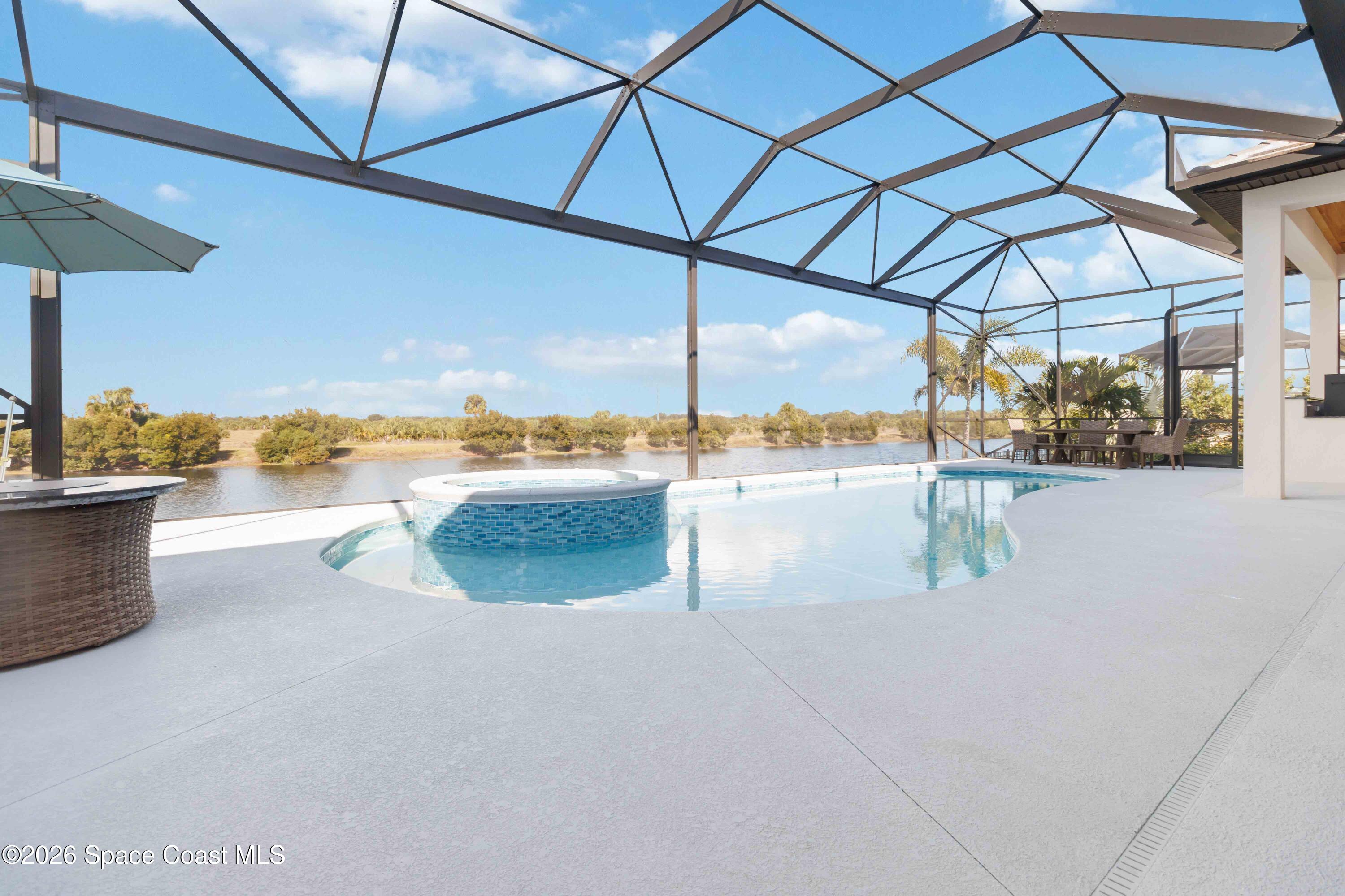 4100 Domain Court Melbourne, FL 32934 - Photo 48 of 52 a view of a swimming pool with a table and chairs under an umbrella