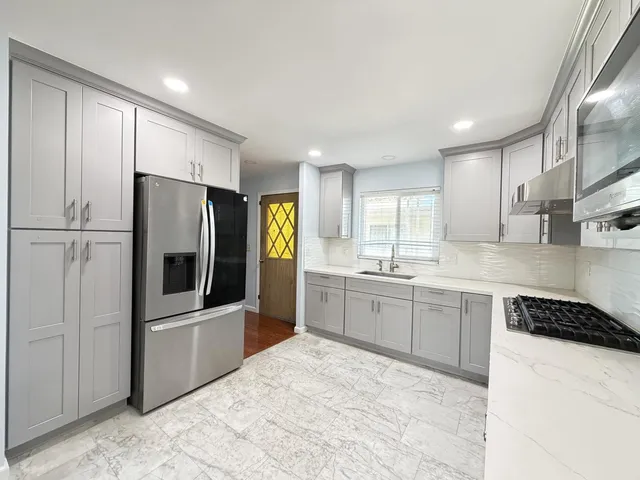 a kitchen with granite countertop a refrigerator and a sink