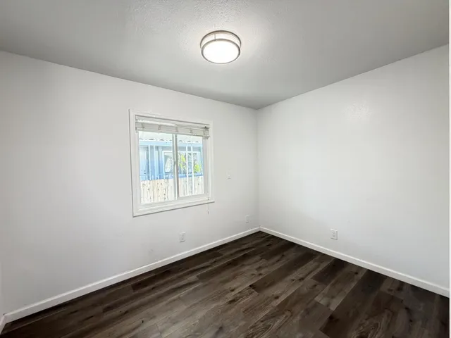 a view of a room with wooden floor and window