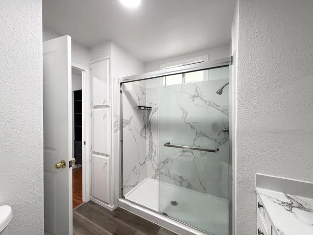 a bathroom with a glass shower door and a window