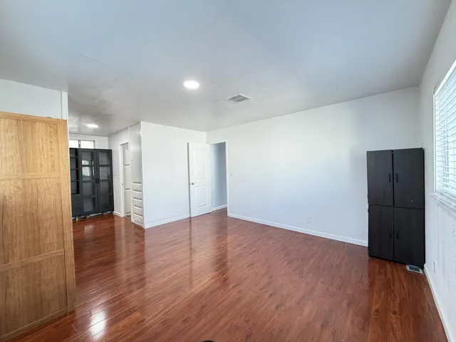 a view of an empty room with wooden floor