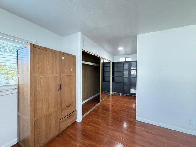 a view of empty room with wooden floor and entryway
