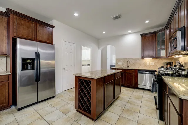 a kitchen with stainless steel appliances granite countertop a stove a refrigerator and a sink