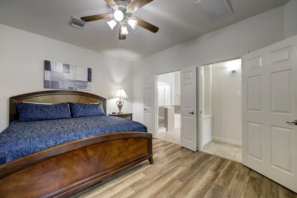 a bedroom with a large bed and a chandelier