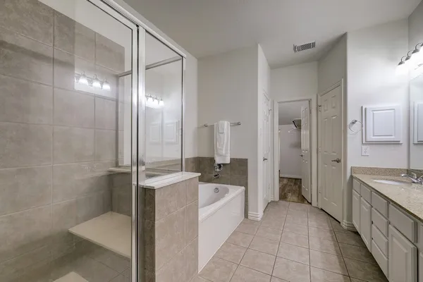 a bathroom with a bathtub shower sink mirror and toilet
