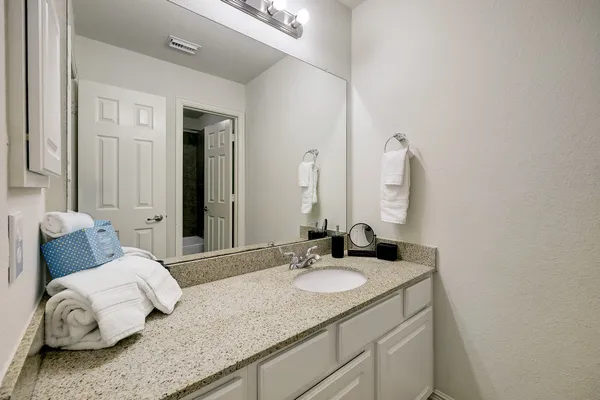 a bathroom with a granite countertop sink and a mirror