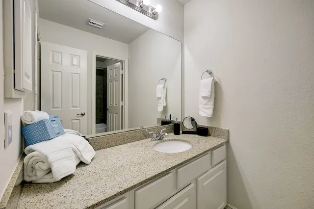 a bathroom with a granite countertop sink and a mirror