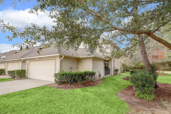 a front view of a house with a garden and plants
