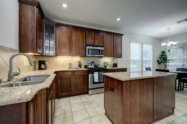 a kitchen with stainless steel appliances granite countertop a sink stove and refrigerator