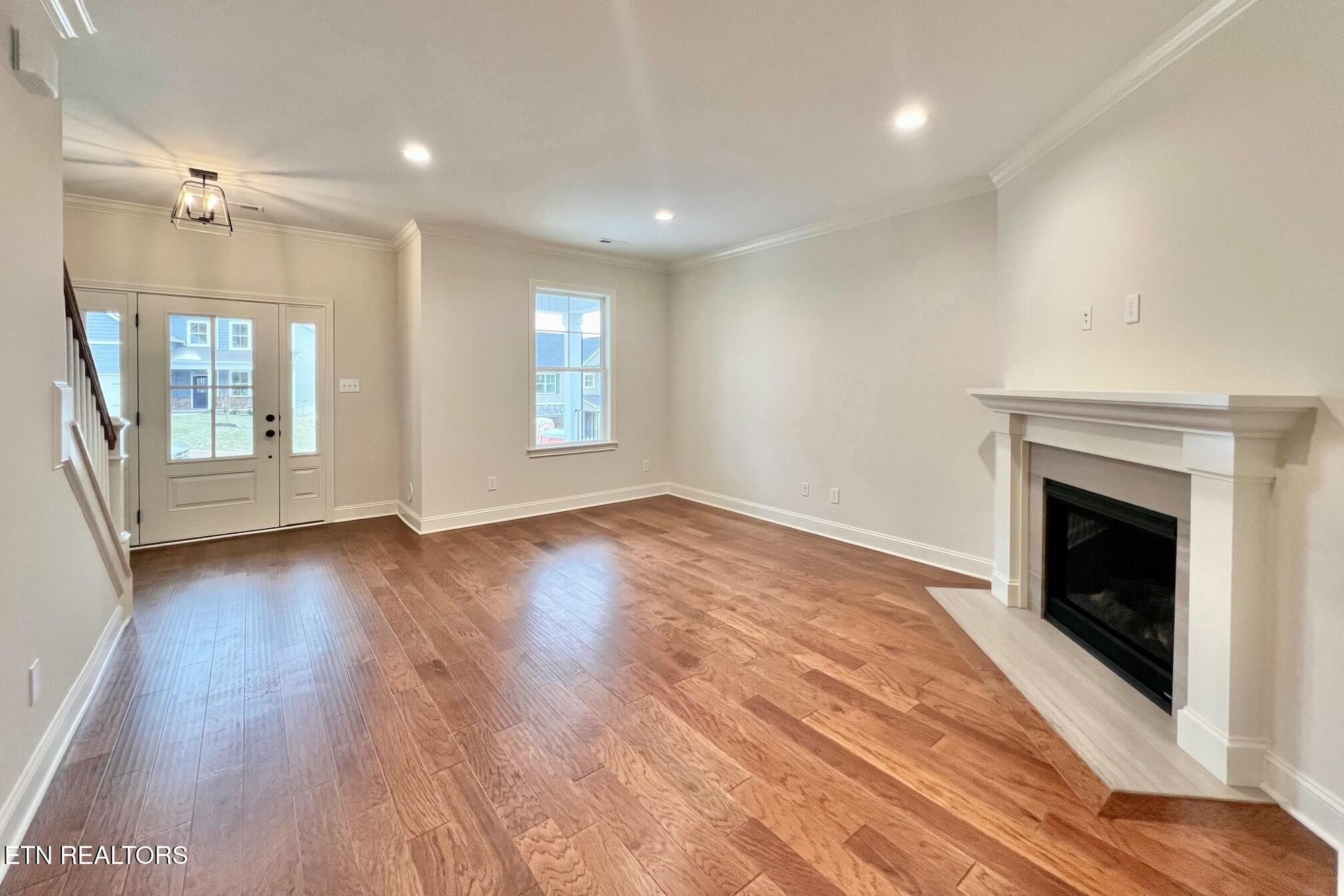 1228 Madison Oaks Road Knoxville, TN 37924 - Photo 4 of 33 an empty room with wooden floor and fireplace