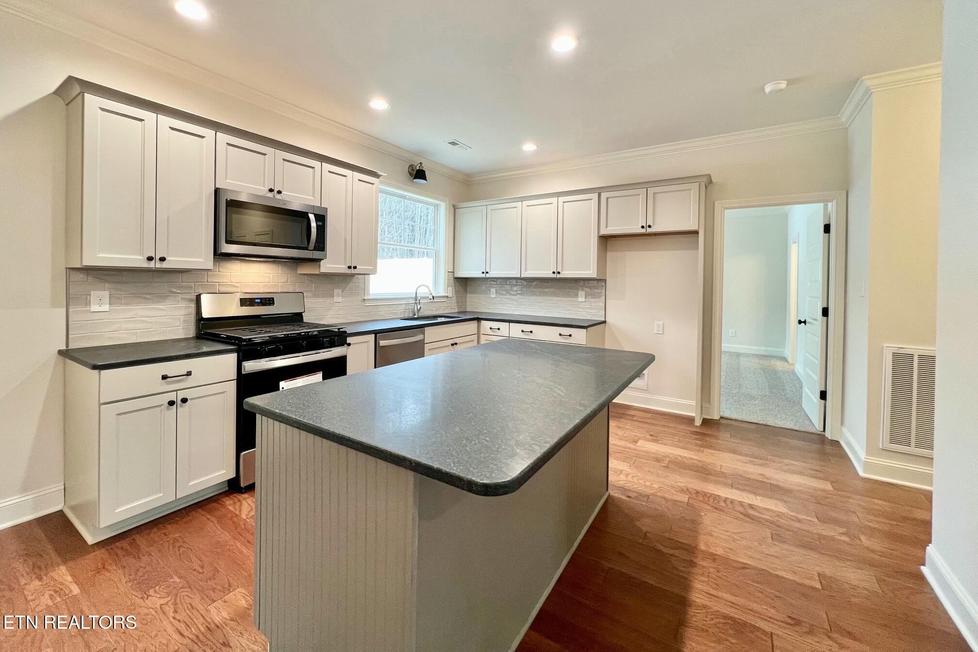 1228 Madison Oaks Road Knoxville, TN 37924 - Photo 7 of 33 a kitchen with stainless steel appliances granite countertop a sink stove and refrigerator