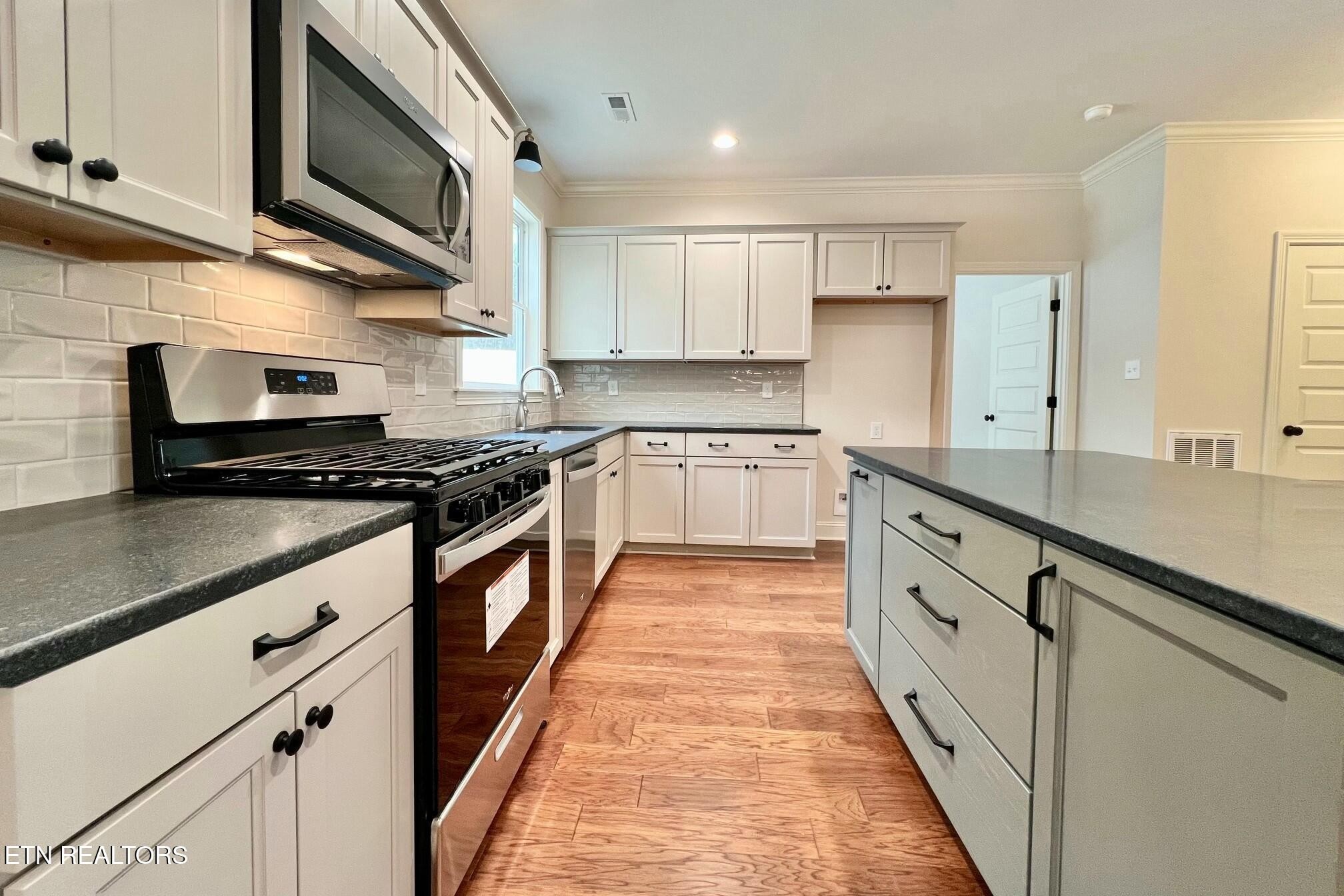 1228 Madison Oaks Road Knoxville, TN 37924 - Photo 8 of 33 a kitchen with stainless steel appliances granite countertop a stove a sink and a microwave