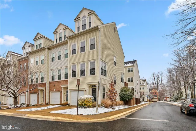 a front view of a building with lot of cars and trees