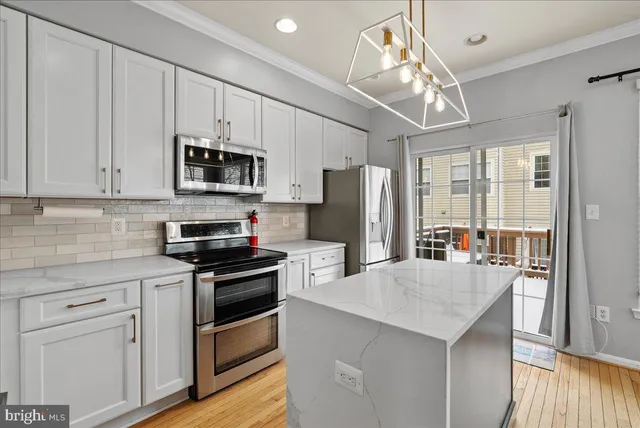 a kitchen with stainless steel appliances a stove refrigerator sink and microwave