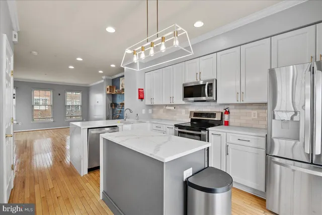 a kitchen with a sink stainless steel appliances and white cabinets