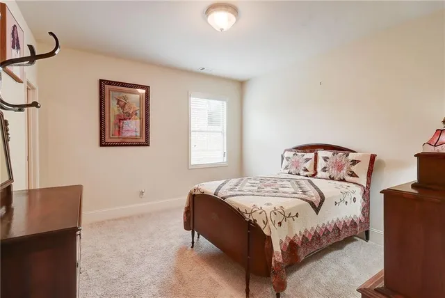 a bedroom with a bed flat screen tv and dresser