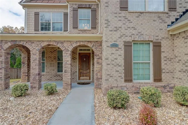 a front view of a house with potted plants