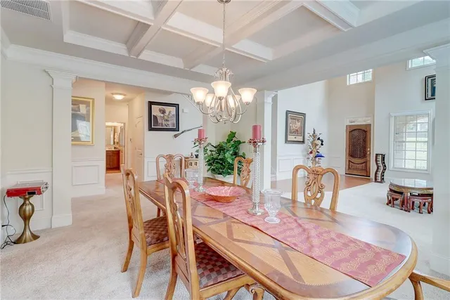 a view of a dining room with furniture and a chandelier