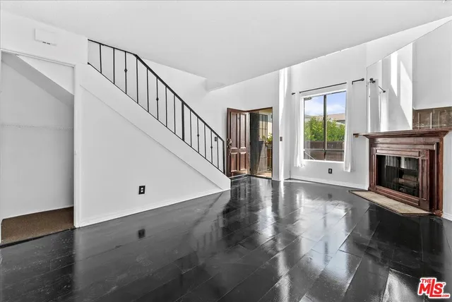 a living room with a fireplace and a wooden floor