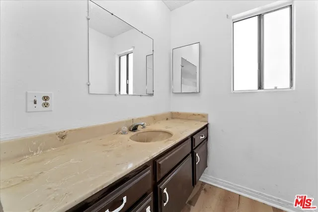 a bathroom with a granite countertop sink and a window