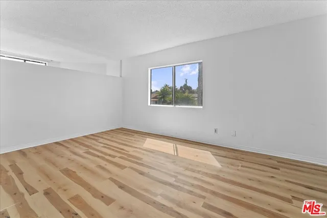 a view of a room with wooden floor and a bed