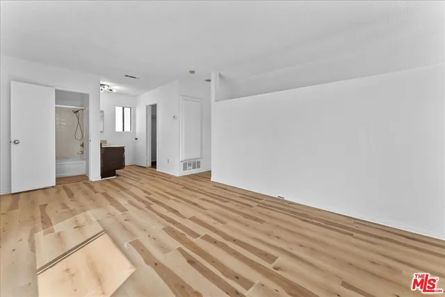 a view of empty room with wooden floor and fireplace