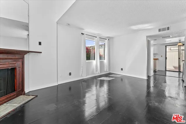 a view of an entryway with wooden floor fireplace and a window