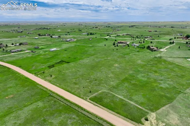 a view of field with grass and a building