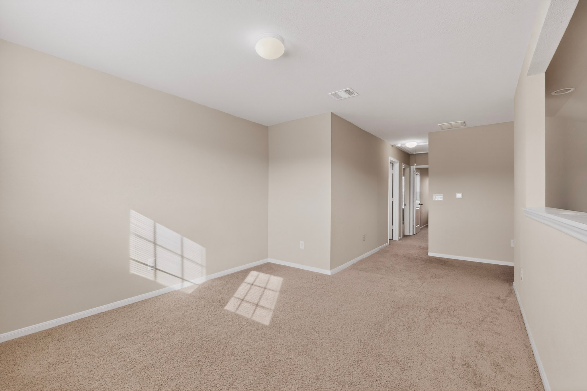 5905 Diamondleaf Bend Austin, TX 78724 - Photo 24 of 38 Spacious room featuring neutral carpeting, light-toned walls, and a flush-mount ceiling fixture
