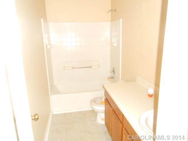 7441 Tuckaseegee Road Kannapolis, NC 28081 - Photo 8 of 14 a bathroom with a granite countertop sink a toilet and shower