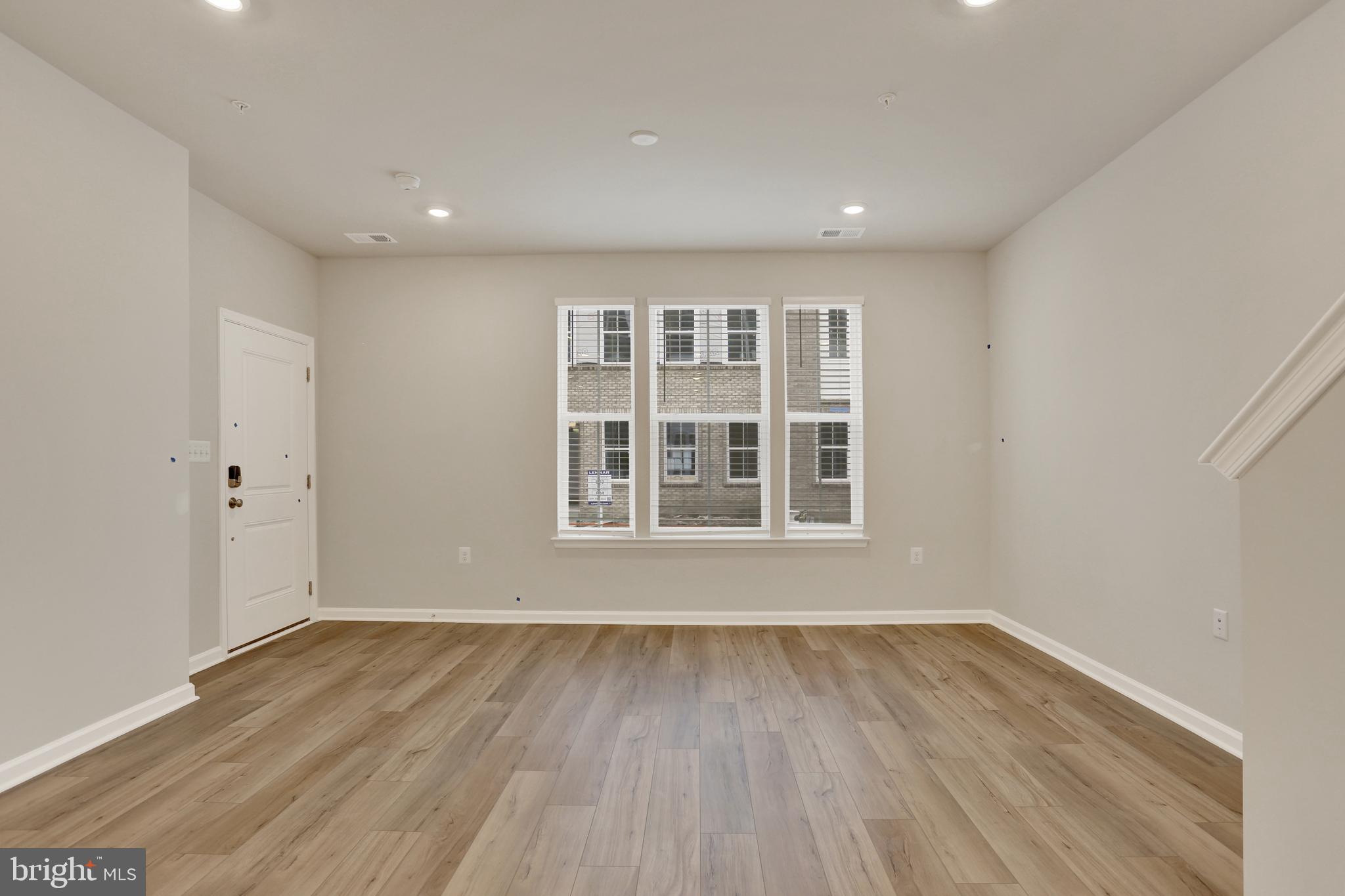 9664 Swallowtail Lane Manassas, VA 20110 - Photo 13 of 95 a view of an empty room with wooden floor and windows