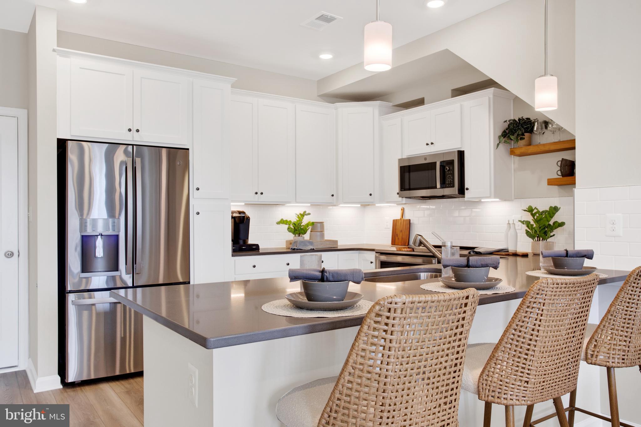9664 Swallowtail Lane Manassas, VA 20110 - Photo 17 of 95 a kitchen with stainless steel appliances a refrigerator a stove a sink dishwasher a dining table and chairs with wooden floor