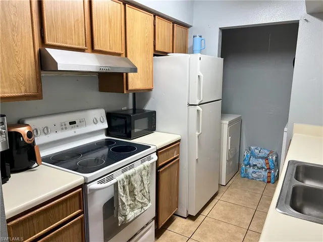 a kitchen with a refrigerator sink stove and cabinets