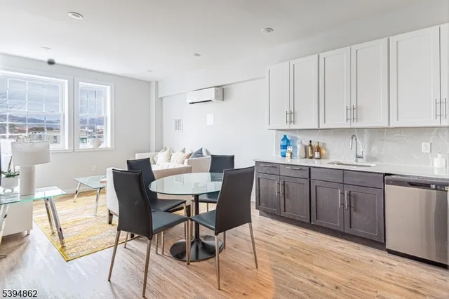 a kitchen with a dining table chairs and white cabinets