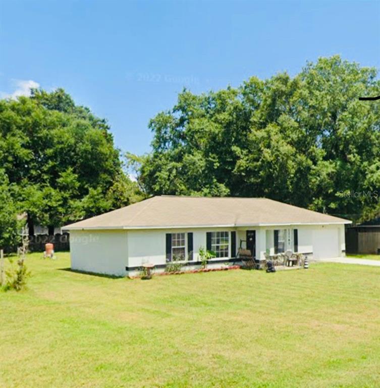 a front view of a house with a garden and swimming pool