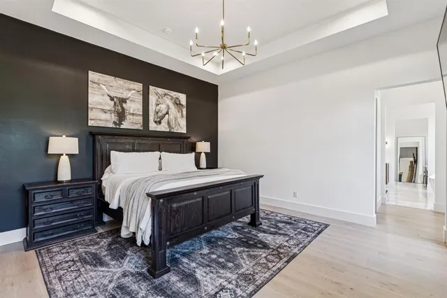 a bedroom with a bed and a chandelier