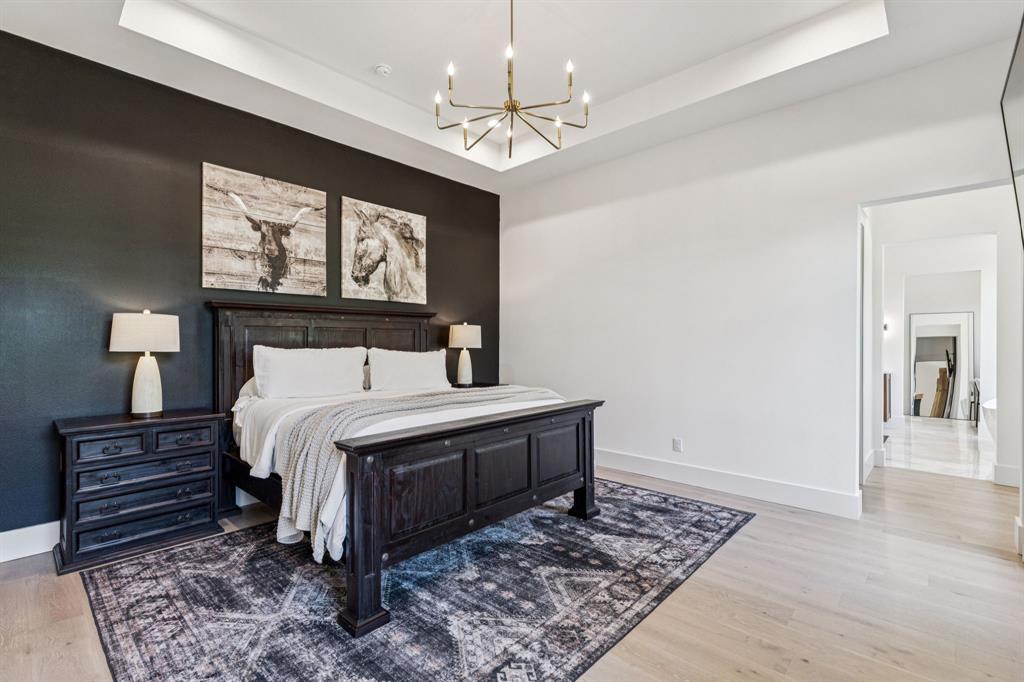 1890 McConnell Road Gunter, TX 75058 - Photo 15 of 40 a bedroom with a bed and a chandelier