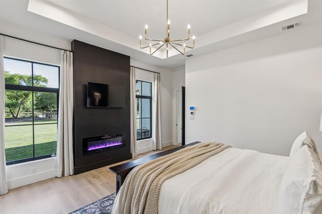 1890 McConnell Road Gunter, TX 75058 - Photo 16 of 40 a bedroom with a bed and a chandelier