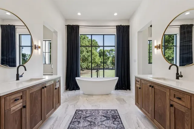 a bathroom with a double vanity sink a mirror and a bathtub