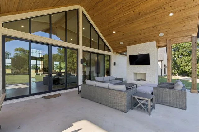 a living room with furniture tv and a floor to ceiling window