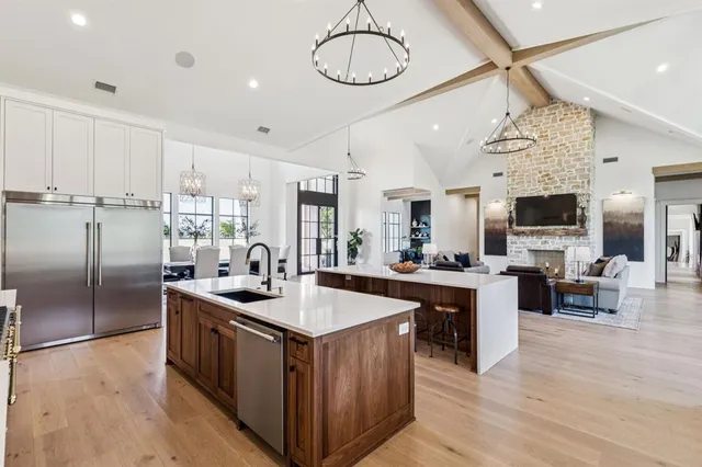 a kitchen with stainless steel appliances granite countertop a sink a stove and refrigerator