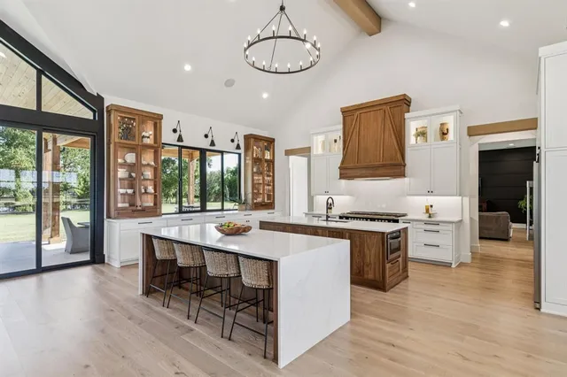 a kitchen with stainless steel appliances granite countertop a stove and chairs